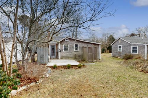 a small house with a porch and a yard at Cozy Escape on the Cape in Eastham