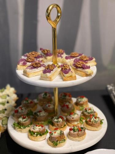 a three tiered plate of pastries on a table at Aria by Brilliant in Zalău