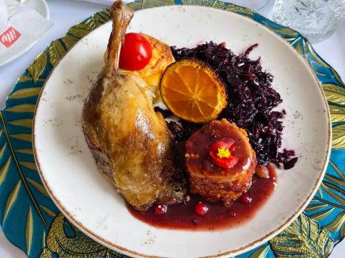 a plate of food with a chicken and cranberry sauce at Aria by Brilliant in Zalău