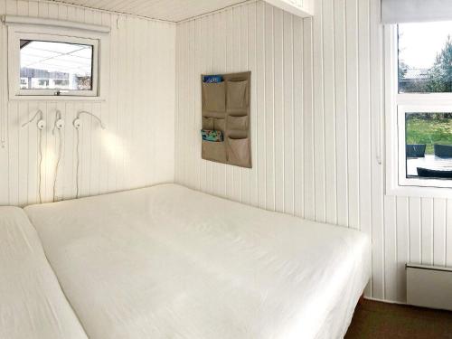 ein weißes Bett in einem Zimmer mit 2 Fenstern in der Unterkunft Holiday home Middelfart IV in Middelfart