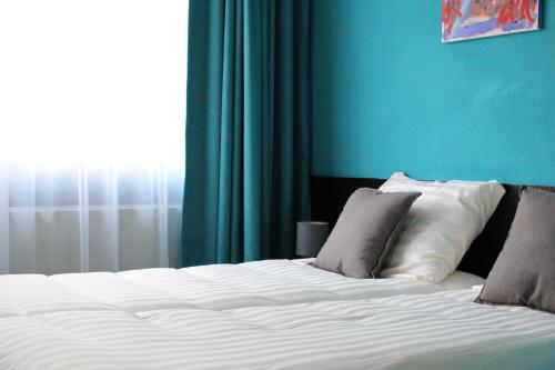 a bed with white sheets and pillows in a room at Hotel De Elderschans in Aardenburg