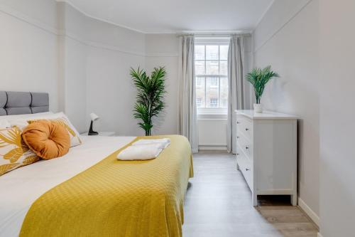 a bedroom with a bed with a yellow blanket at Spacious 1 Bed Apartment- Close to Kings Cross Station in London
