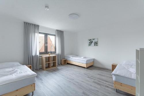 オーバーハウゼンにあるT&K Apartments-Comfortable 2 and 3 room apartments in Oberhausenのベッドが2つと窓がある白い部屋