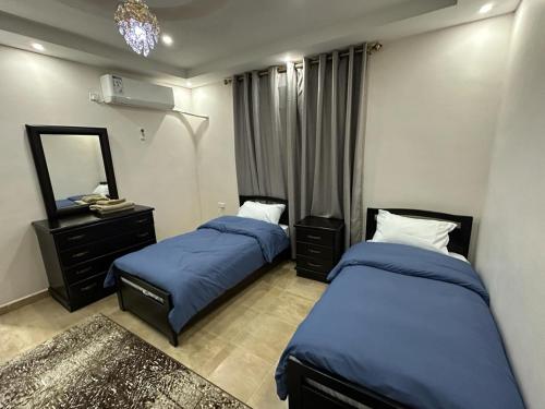 una camera con due letti e uno specchio di Amro Petra Apartment a Wadi Musa