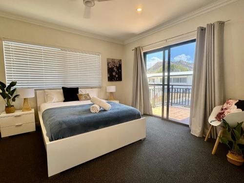 Un dormitorio con una cama y una ventana grande. en Townsville Apartments and Homes on The Strand, en Townsville
