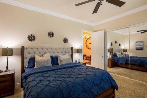 1 dormitorio con 1 cama azul y ventilador de techo en Luxury Residential Estates Pool Spa Firepit, en Lake Havasu City