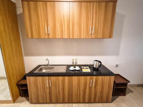 a kitchen with a sink and wooden cabinets at Raja Hotel Kuta Mandalika Resort & Convention in Kuta Lombok