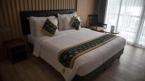 a bedroom with a large bed with white sheets and pillows at Raja Hotel Kuta Mandalika Resort & Convention in Kuta Lombok