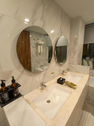 a white bathroom with a sink and a mirror at Raja Hotel Kuta Mandalika Resort & Convention in Kuta Lombok