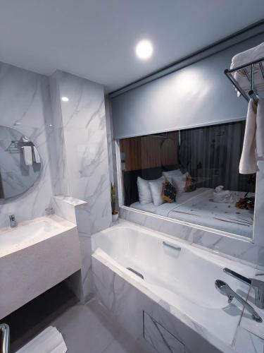 a bathroom with a tub and a large mirror at Raja Hotel Kuta Mandalika Resort & Convention in Kuta Lombok