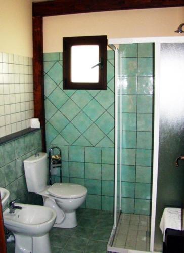 a bathroom with a toilet and a sink at Agriturismo Ghiritina in Francavilla di Sicilia
