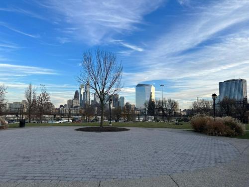 a tree in a park with a city in the background at Charming 1br In Univ City in Philadelphia