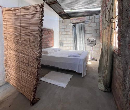 um quarto com uma cama numa parede de tijolos em Hostal Brisas del Ometepe em Rivas