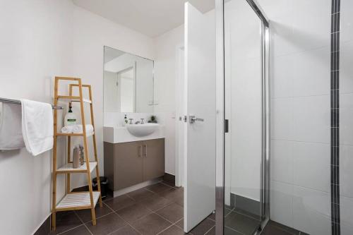 a bathroom with a glass shower and a sink at Panoramic views 3BR Cairns City Apartment in Cairns