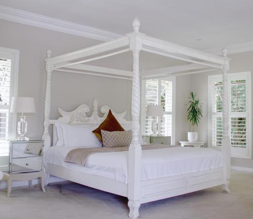 a white bedroom with a white canopy bed at The Wesley Boutique Hotel & Spa in Johannesburg