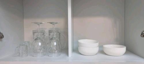 a shelf with glass vases and bowls on it at NK House in Anyang