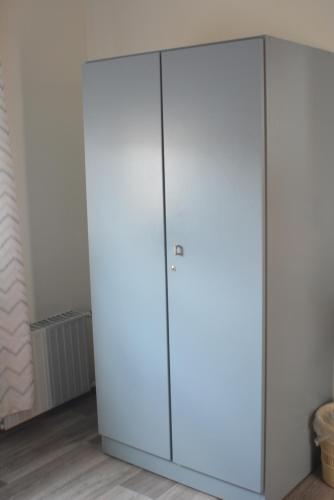 a large white wardrobe in a room with wood floors at Budgethotel Stadtbett Wolfsburg in Wolfsburg