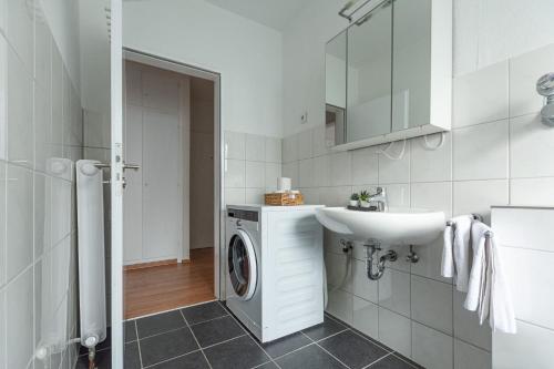 オーバーハウゼンにあるT&K Apartments-Comfortable 2 and 3 room apartments in Oberhausenの洗濯機と洗面台を備えたバスルーム