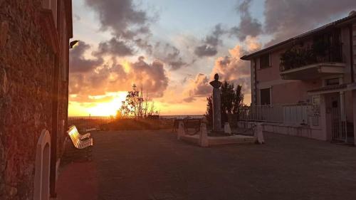 - un coucher de soleil sur une terrasse dotée de bancs en face d'un bâtiment dans l'établissement Casa Peppuccio, 