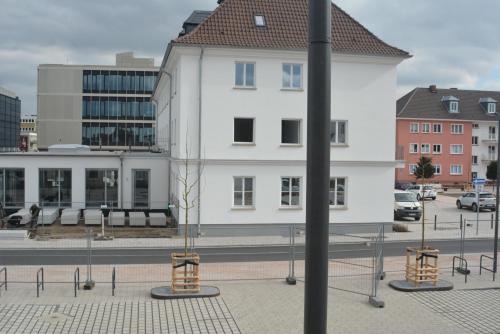 a white building with a tree in front of it at Budgethotel Stadtbett Wolfsburg in Wolfsburg