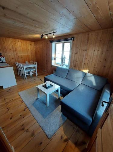 - un salon avec un canapé bleu et une table dans l'établissement Mysig stuga, à Orsa