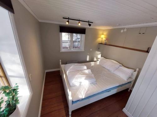 ein weißes Bett in einem Zimmer mit Fenster in der Unterkunft Mysig stuga in Orsa