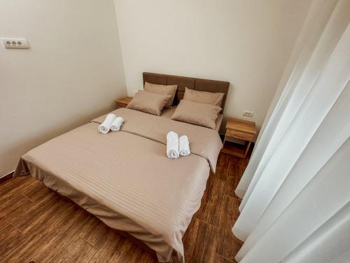 a bedroom with a bed with two towels on it at Kiko apartmani LUX in Zrenjanin