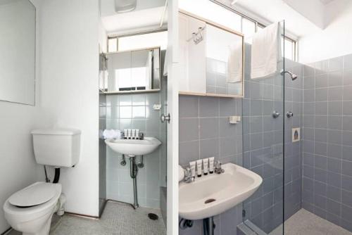 a bathroom with a toilet and a sink at Studio with Stunning Views and Free Parking in Sydney