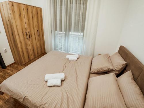 a bedroom with a bed with two towels on it at Kiko apartmani LUX in Zrenjanin