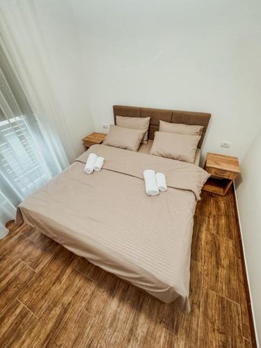 a bedroom with a bed with two towels on it at Kiko apartmani LUX in Zrenjanin