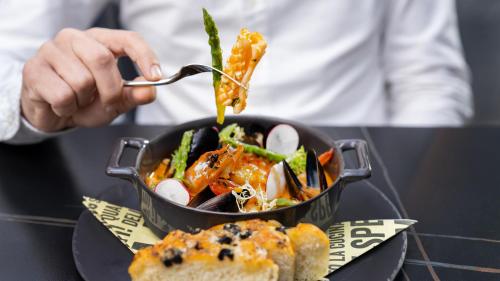 a person eating a bowl of food on a table at The Abdali Boulevard Hotel in Amman