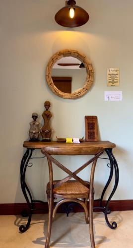a dressing table with a mirror and a chair at Kambaku River Lodge in Malelane