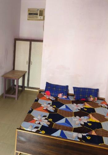 a bedroom with a bed with a quilt on it at BHOLE VATIKA in Mathura