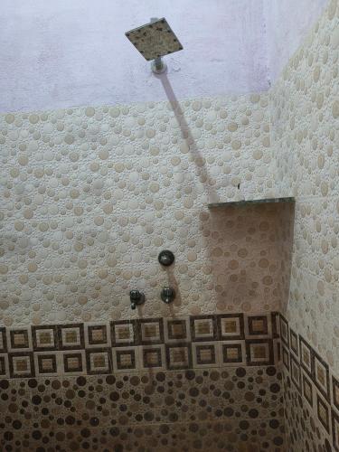 y baño con ducha y pared de azulejos. en BHOLE VATIKA, en Mathura