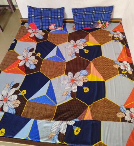 BHOLE VATIKA في ماثورا: سرير مع لحاف جميل وبه زهور