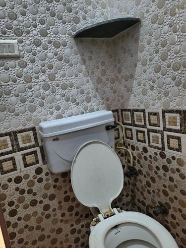 a bathroom with a white toilet in a room at BHOLE VATIKA in Mathura