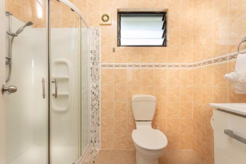 a bathroom with a toilet and a shower at Bella Beach Bungalows in Rarotonga