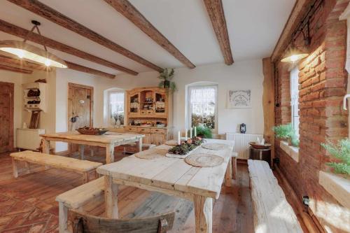 une salle à manger avec des tables en bois et un mur en briques dans l'établissement Agroturystyka Taszówka Obórka, à Taszów