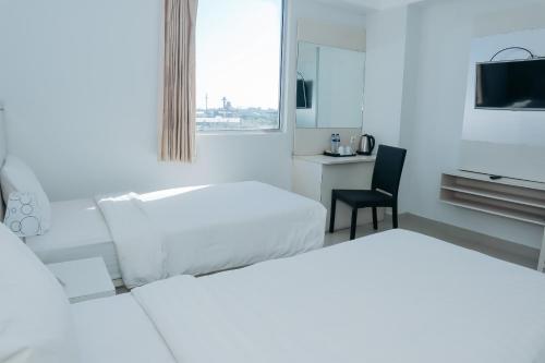 Ένα ή περισσότερα κρεβάτια σε δωμάτιο στο Liberta Hotel Grand Sayang Makassar