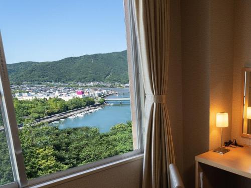 a window in a hotel room with a view of a river at KAMENOI HOTEL Toba in Toba