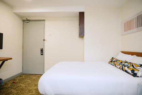 a bedroom with a white bed and a closet at The Concept Hotel KL- TBS in Kuala Lumpur