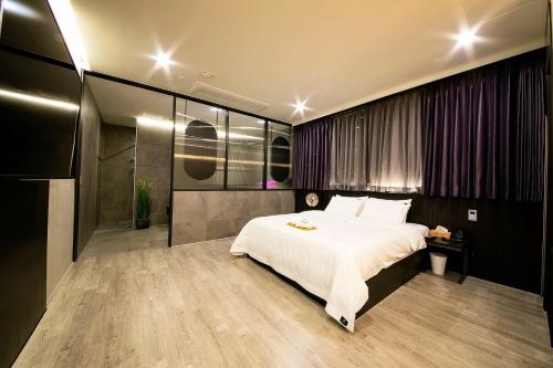 a bedroom with a large white bed in it at Epoche Hotel in Jinju