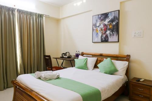 1 dormitorio con 1 cama con almohadas verdes y blancas en Hotel Grandview en Chinchiwad