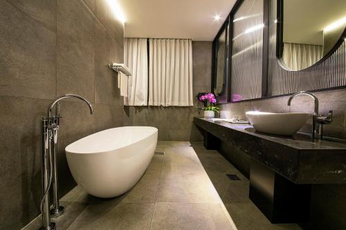 a bathroom with two sinks and a large tub at Epoche Hotel in Jinju