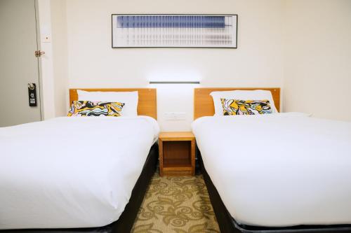 two beds sitting next to each other in a room at The Concept Hotel KL- TBS in Kuala Lumpur