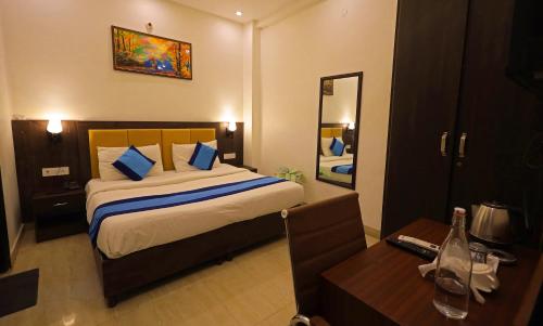a bedroom with a bed and a desk and a mirror at Hotel Admire Stay in Noida