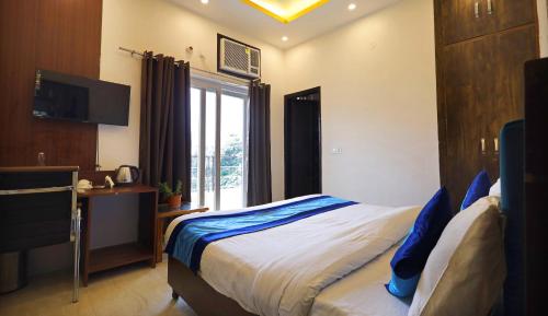 a bedroom with a bed and a desk and a window at Hotel Admire Stay in Noida