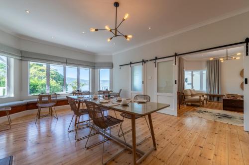 a dining room and living room with a table and chairs at Hide-Away Guest House in Knysna