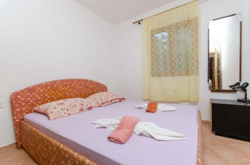 ein Bett mit zwei Paar Handschuhen und einem Spiegel in der Unterkunft Apartments Sandra in Stomorska