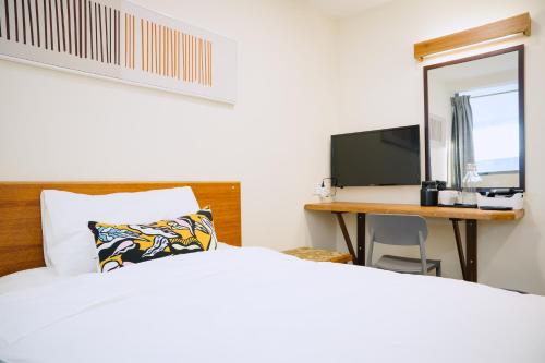 a bedroom with a bed and a desk with a computer at The Concept Hotel KL- TBS in Kuala Lumpur
